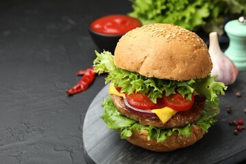 Delicious hamburger with patty served on black table, closeup. Space for text