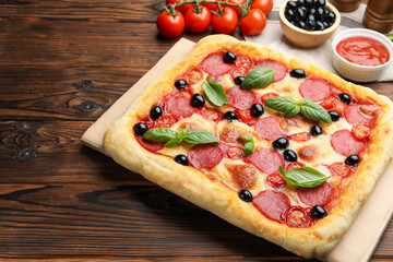 Tasty homemade pizza and ingredients on wooden table, closeup