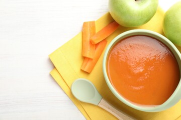 Baby food. Tasty puree in bowl, different ingredients and spoon on wooden table, flat lay. Space...