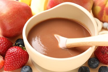 Baby food. Tasty puree in bowl and ingredients on table, closeup
