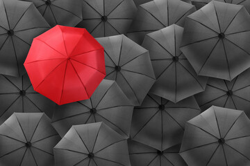 Red umbrella among black ones, top view
