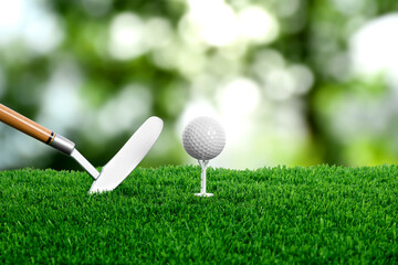 Golf ball on green grass and club outdoors, closeup