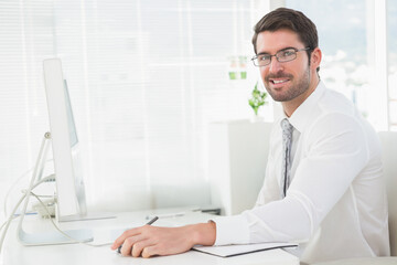 Man wearing business attire working at office desk with monitor, notebook, copy space