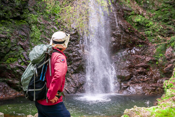 滝を見つめる登山家