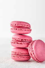 Stack of pink Macarons on white textured background isolated