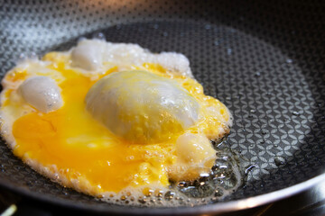 An egg frying in a frying pan photographed very close up