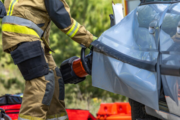Firefighters pull a man trapped in a car after a car accident