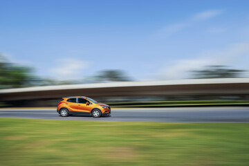 Fast car on the highway. Side view of a car driving down the street at high speed on a blurred background