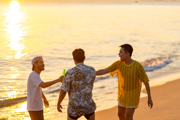 Happy Asian man travel nature the sea drinking beer on the beach on summer holiday vacation. Group...