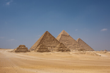 The Great Pyramids of Giza stand majestically in the sandy landscape, showcasing ancient Egyptian...