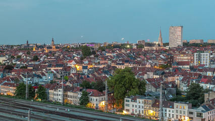 Obraz premium Aerial day to night timelapse panorama over Brussels skyline in Schaerbeek with Saint-Servais Church and Town Hall