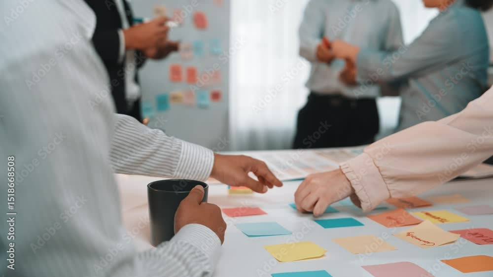 Poster a dynamic office setting depicting a team engaging in discussion and brainstorming with sticky notes