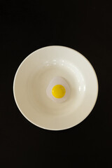 fried egg on a plate on black background