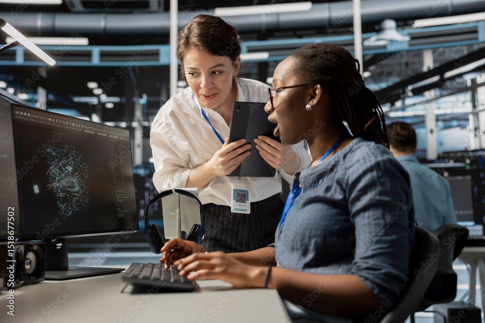 Poster data center technicians look at visualization on pc screen to pinpoint equipment performance issues.