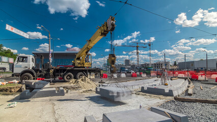Installing concrete plates by crane at road construction site timelapse.