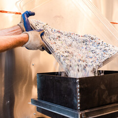 Eco-Friendly Industry –Worker Dumping Shredded Recycled Plastic at Recycling Center