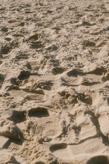 chain of footprints in the sand. The footprints of human shoes are arranged in a row and very close to each other, the beach is trampled by feet.