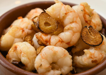 Ceramic bowl with fried shrimps and garlic, closeup