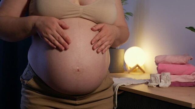 Pregnant woman make heart shape with hands and feel love for unborn baby in belly. Awaiting for baby. Concept of maternity and pregnancy care