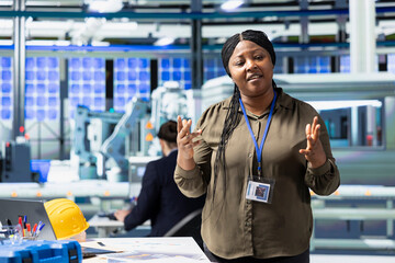 Black woman inspector explaining the new photovoltaics production, obtaining cheaper eco friendly...