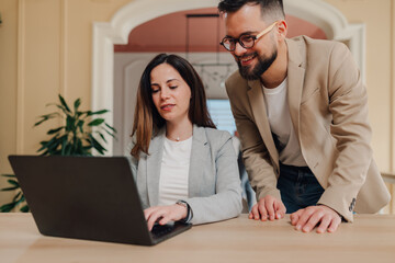 Businesspeople working together on laptop in modern office