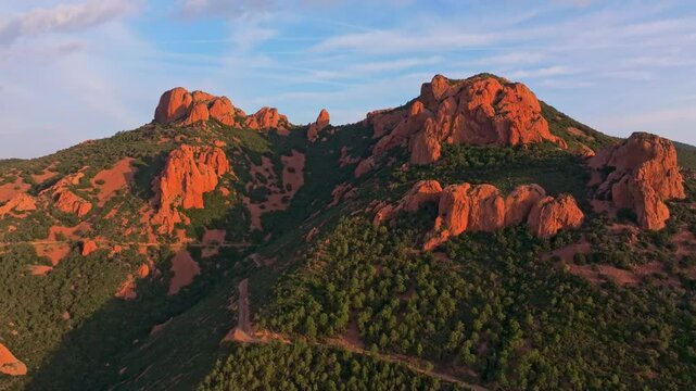 Aerial view of red cliffs and coastal road cutting through Esterel, France. Aerial drone video
