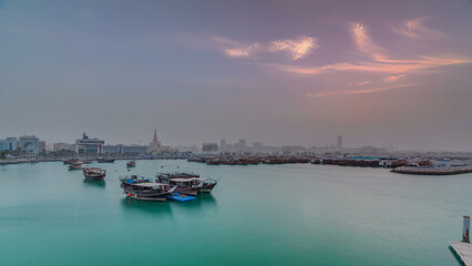 Fototapeta premium Sunset at Doha Bay timelapse with Traditional Wooden Dhow Fishing Boats.