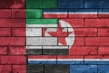 Obraz premium colourful painted big national flag of north korea and flag of united arab emirates on a massive old brick wall background. concept
