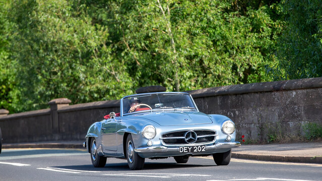 Milton Keynes,Bucks,UK - June 1st 2025:  1956 blue Merceds  190 sl roadster car driving on a British road.