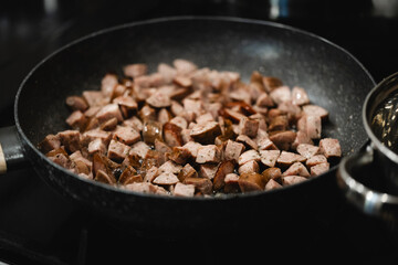Frying Pan Full of Sizzling Sausage: Home Cooking Tasty Pieces of Meat for Lunch or Dinner
