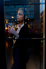 Young woman holding a wine glass in front of the window