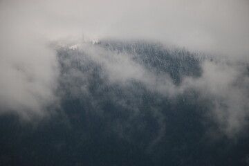 Cloud-kissed Summit: A misty landscape of a towering mountain peak, shrouded in soft, ethereal...