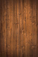 Wood background texture highlighting brown wooden floor grain. Natural rustic backdrop depicting a surface comprising of slats of lumber.
