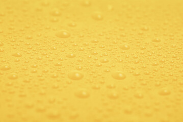 Texture of water drops on yellow plastic.