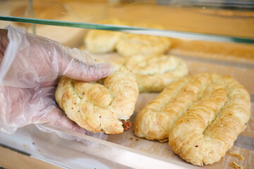 Delicious pastry being picked up in a bakery