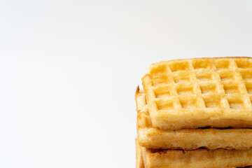 Stack of square golden waffles on a white background with copy space. Ideal for breakfast, food packaging, menu design, and bakery-related concepts