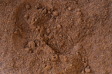 Close-up texture of ground coffee showing its rich brown color and granulated surface. Ideal for backgrounds, food and drink concepts, coffee culture, and product packaging