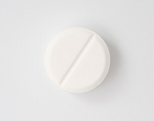 Close-up of a single white round tablet on a clean white background. Ideal for medical, pharmaceutical, healthcare, and drug-related themes in advertising or education