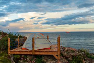 Tent on a wooden platform by the sea on a beautiful summer day