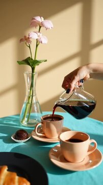 Pouring Coffee into Pastel Cups: A Sunlit Breakfast Scene