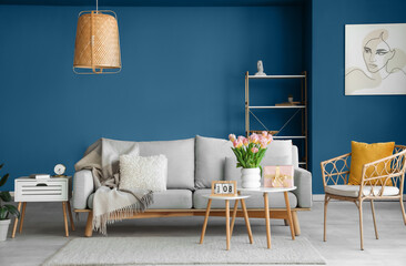 Interior of living room with gift box and tulips for International Women's Day on tables