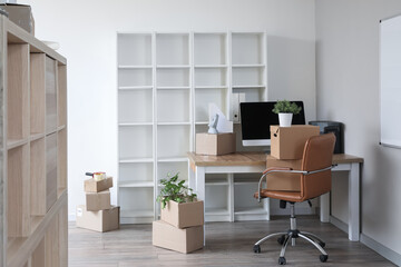 Workplace with cardboard boxes in office on moving day