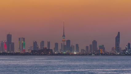 Skyline with Skyscrapers day to night timelapse in Kuwait City downtown illuminated at dusk. Kuwait...