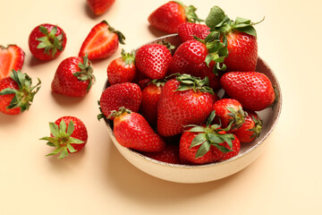 Bowl of fresh strawberries on beige background