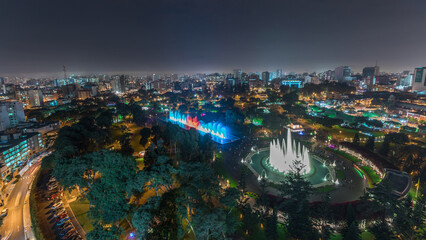 Obraz premium Aerial view to Park of the Reserve with colorful magic water circuit biggest fountain complex night timelapse