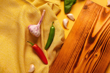 Composition with wooden cutting board and aromatic spices on color background, closeup