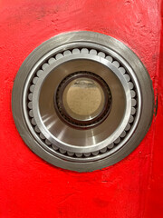 close up of a large roller bearing inserted in a red machine frame