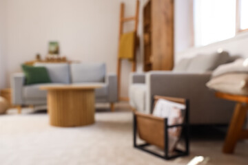 Blurred view of light living room with sofas and table