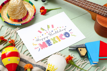 Greeting card with text MEXICO INDEPENDENCE DAY and Mexican decor on green wooden background