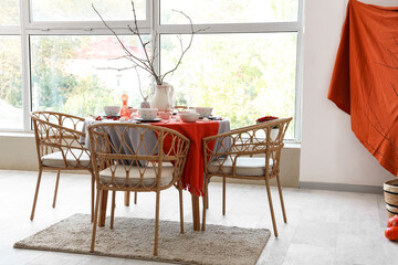 Autumn table setting with tree branches in light dining room
